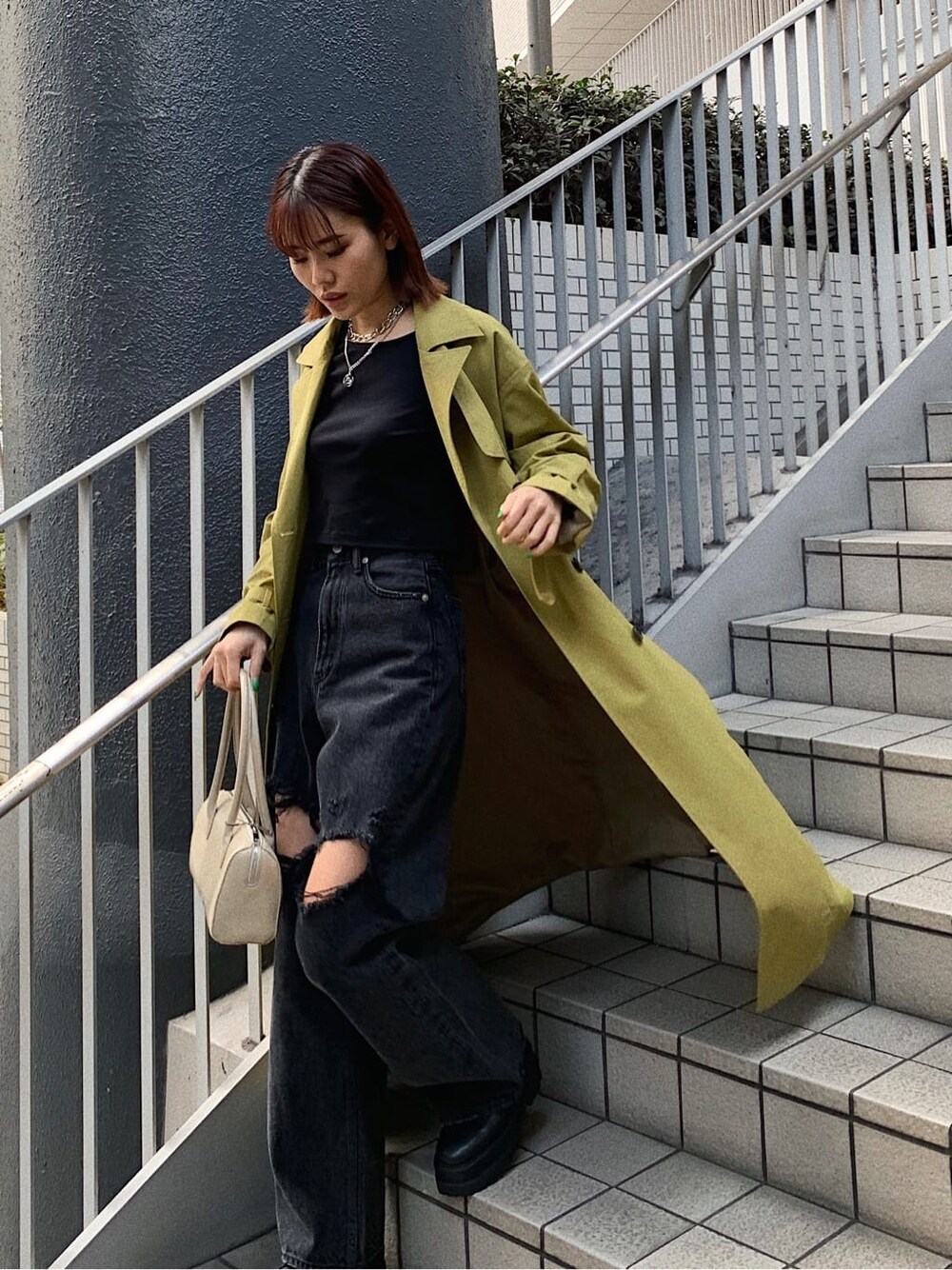 ブラック系のブーツ、ブラック系のデニムパンツ、ベージュ系のボストンバッグを着用したレディースの春コーディネートの2枚目の写真