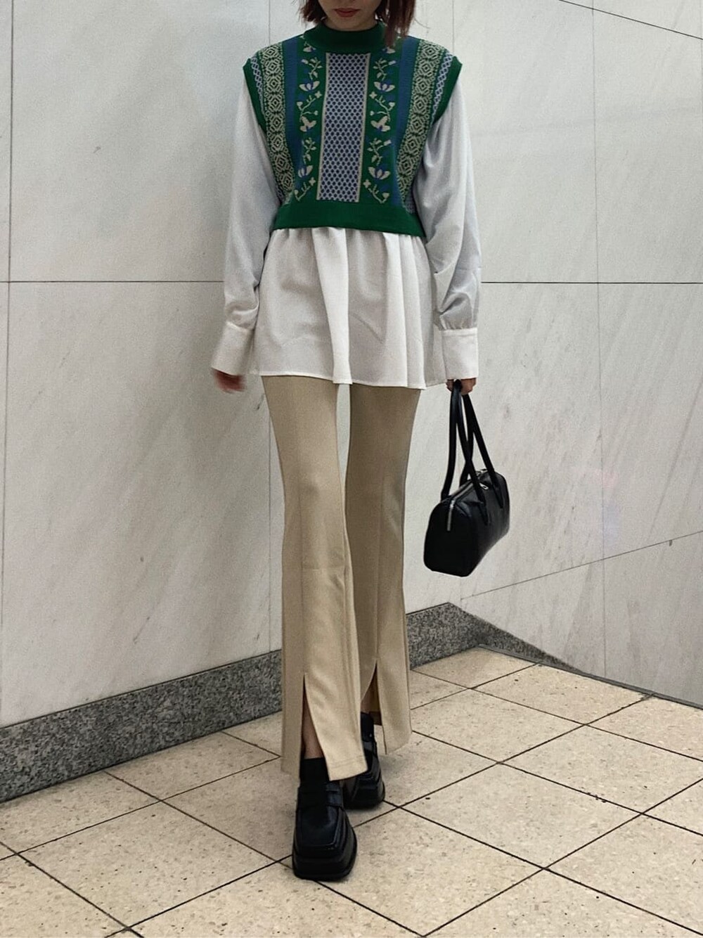 ブラック系のローファー、ブラック系のボストンバッグ、グリーン系のシャツ/ブラウスを着用したレディースの冬コーディネートの2枚目の写真