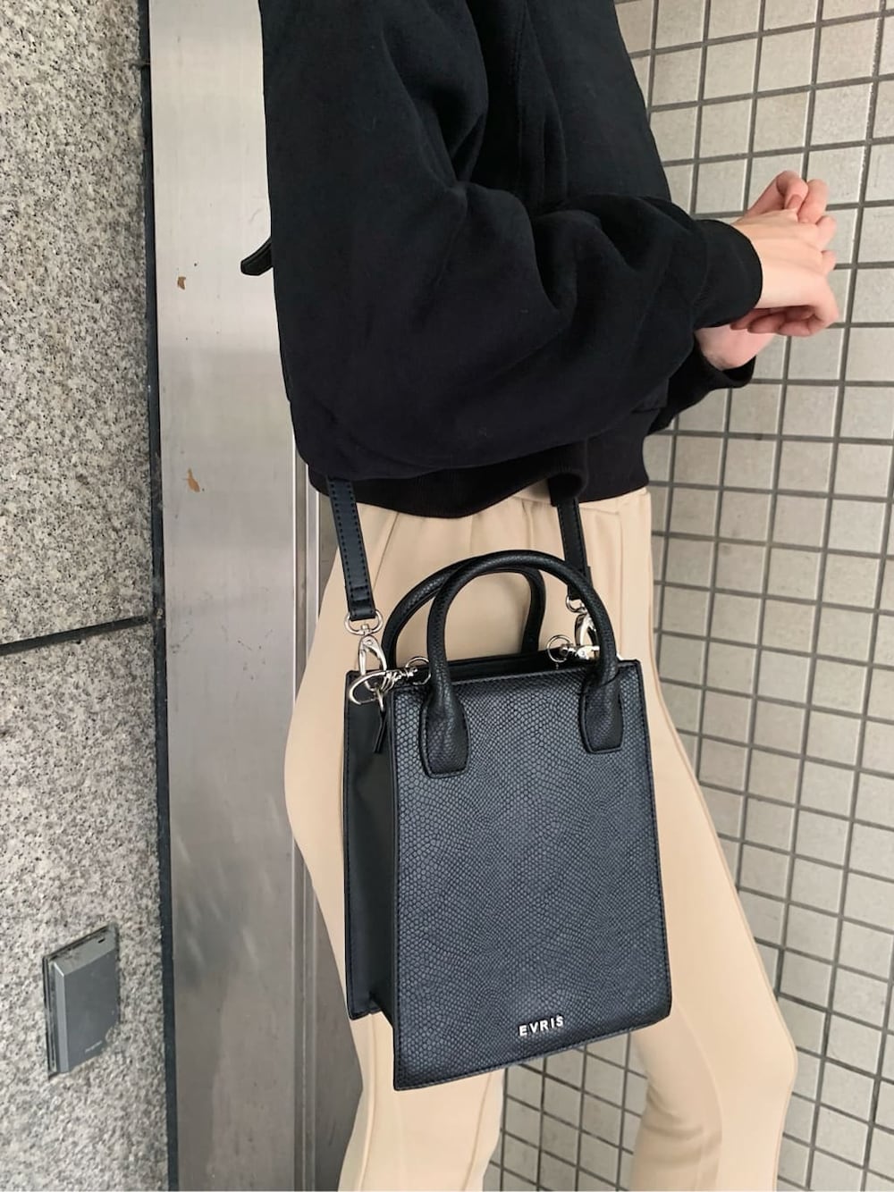 ブラック系のブーツ、ホワイト系のその他パンツ、ブラック系のショルダーバッグを着用したレディースの秋コーディネートの4枚目の写真