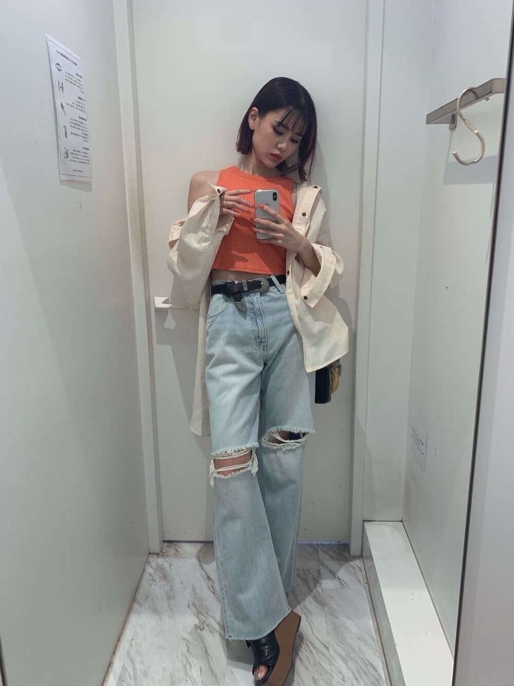 ホワイト系のシャツ/ブラウス、ブラック系のサンダル、ブルー系のデニムパンツを着用したレディースの夏コーディネートの2枚目の写真