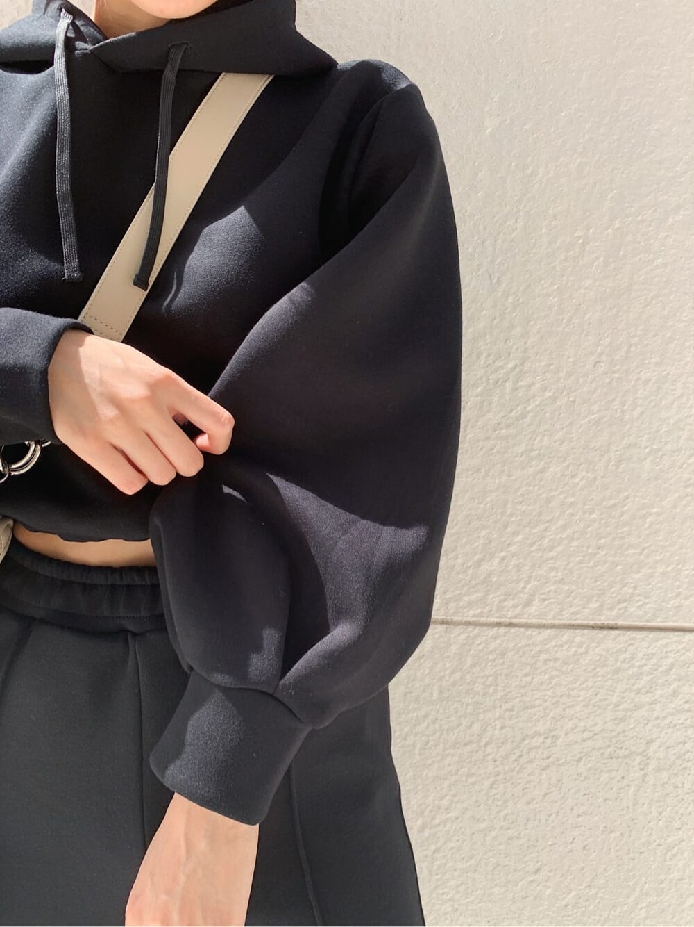 ブラック系のその他パンツ、ホワイト系のショルダーバッグ、ブラック系のパーカーを着用したレディースの秋コーディネートの2枚目の写真