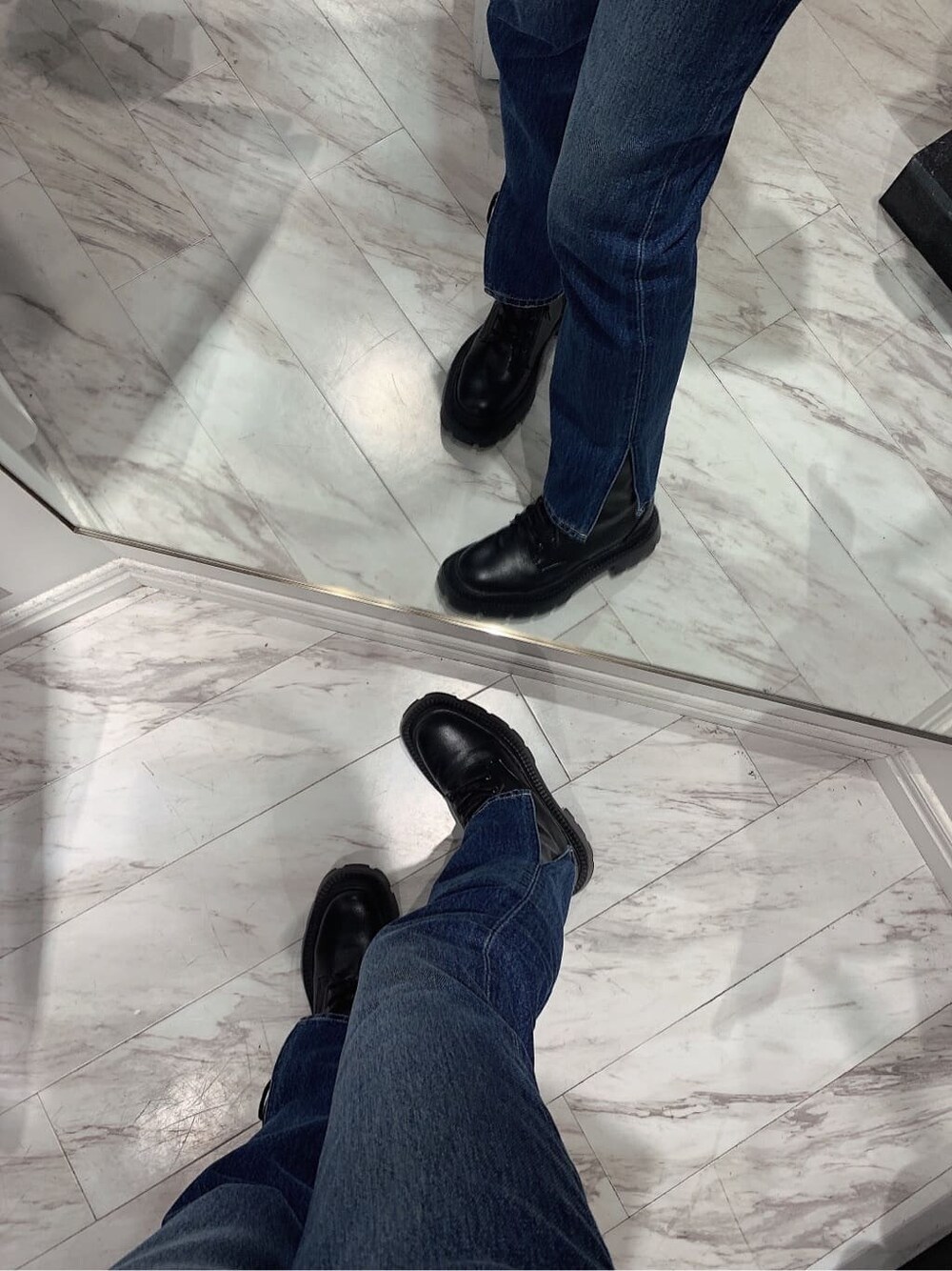 ホワイト系のニット/セーター、ブラック系のブーツ、ブルー系のデニムパンツを着用したレディースの冬コーディネートの6枚目の写真