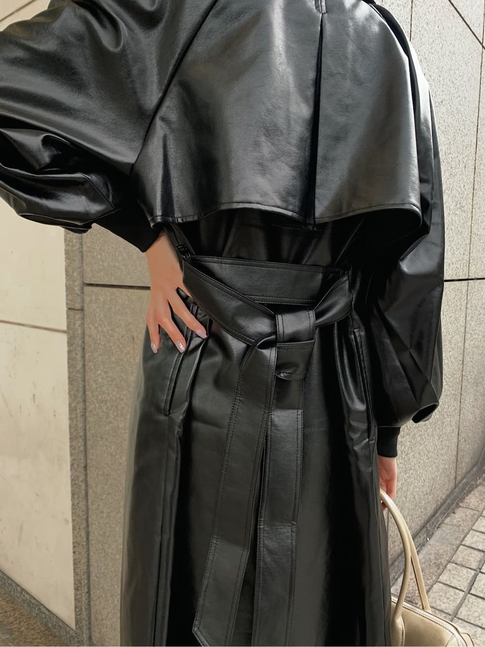 ホワイト系のニット/セーター、ベージュ系のブーツ、ブラック系のトレンチコートを着用したレディースの冬コーディネートの5枚目の写真