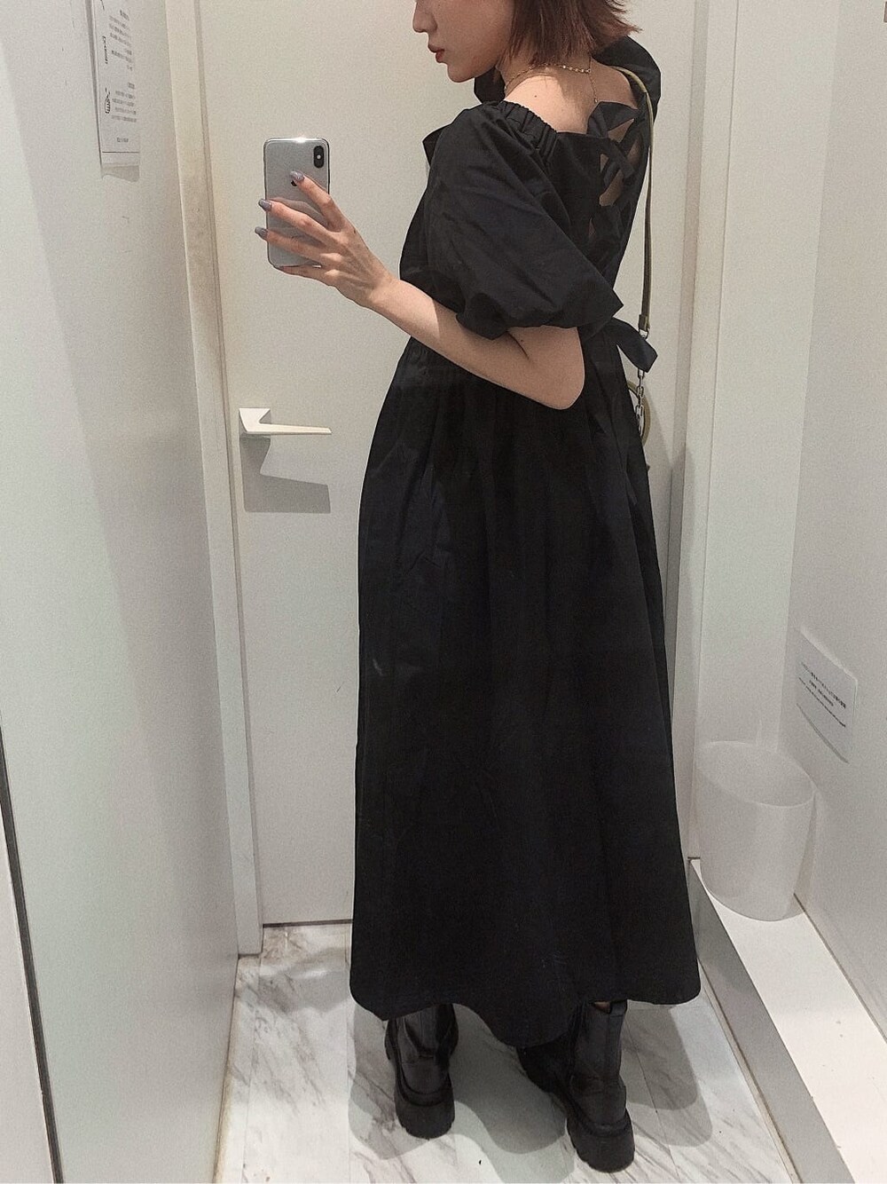 ブラック系のブーツ、イエロー系のショルダーバッグ、ブラック系のワンピースを着用したレディースの春コーディネートの4枚目の写真