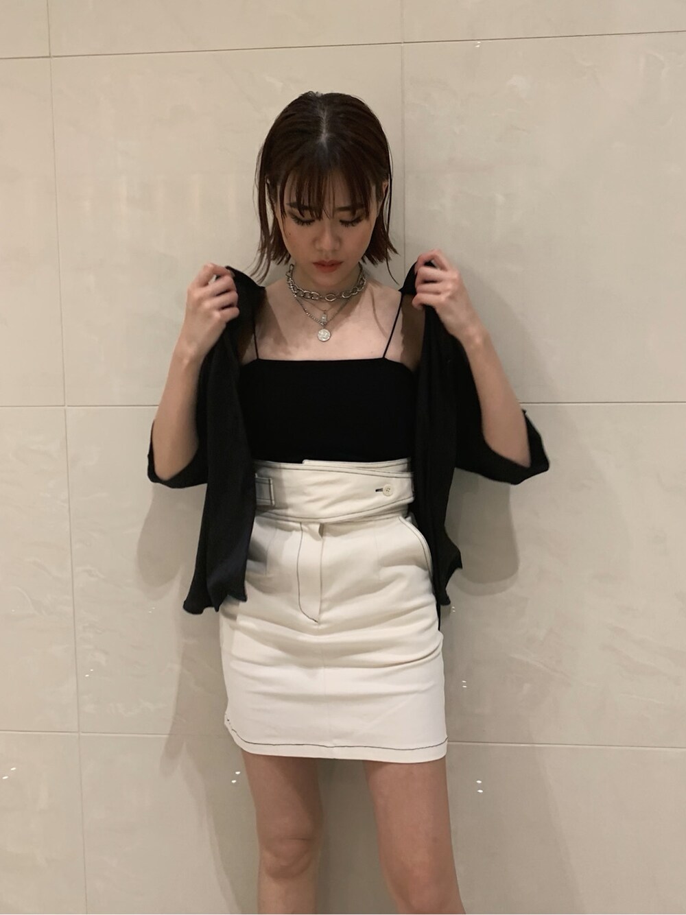 ホワイト系のスカート、ブラック系のサンダル、ブラック系のシャツ/ブラウスを着用したレディースの春コーディネートの4枚目の写真