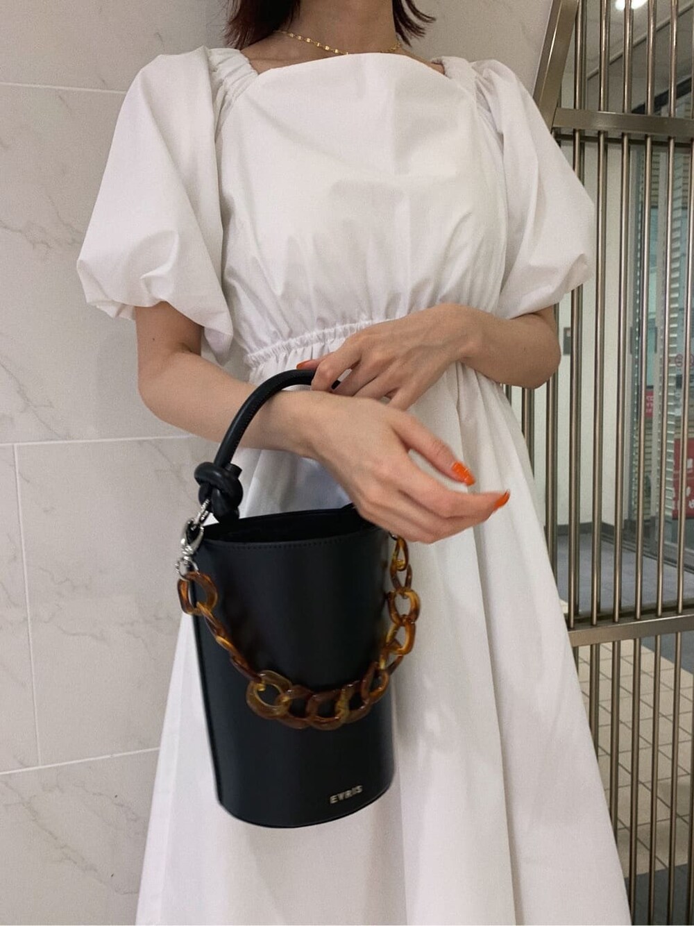 ホワイト系のワンピース、ブラック系のショルダーバッグ、その他のサンダルを着用したレディースの春コーディネートの8枚目の写真