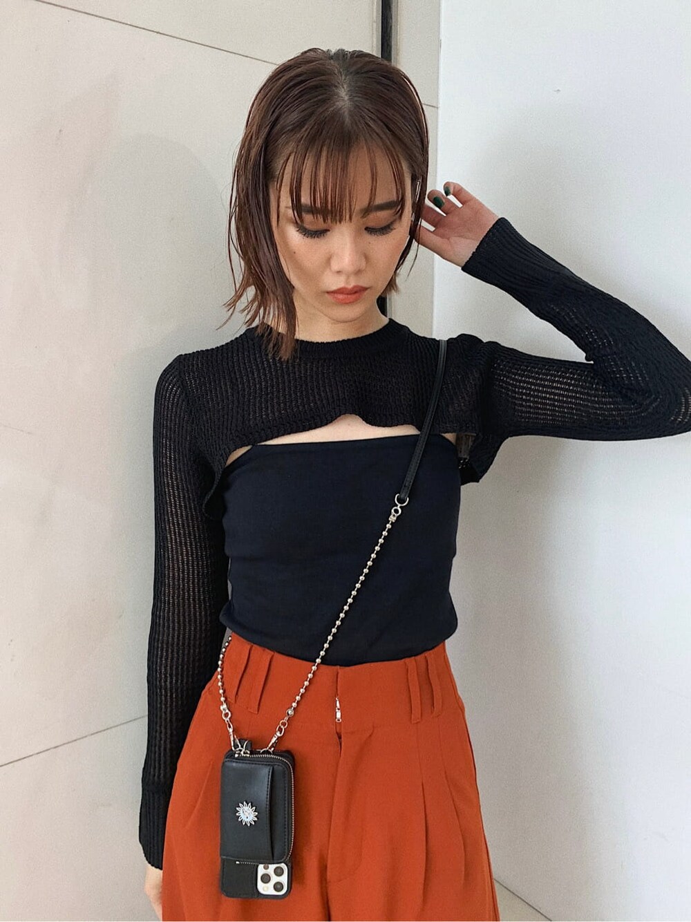 オレンジ系のその他パンツ、ブラック系のローファー、ブラック系のスマホケース/カバーを着用したレディースの秋コーディネートの2枚目の写真