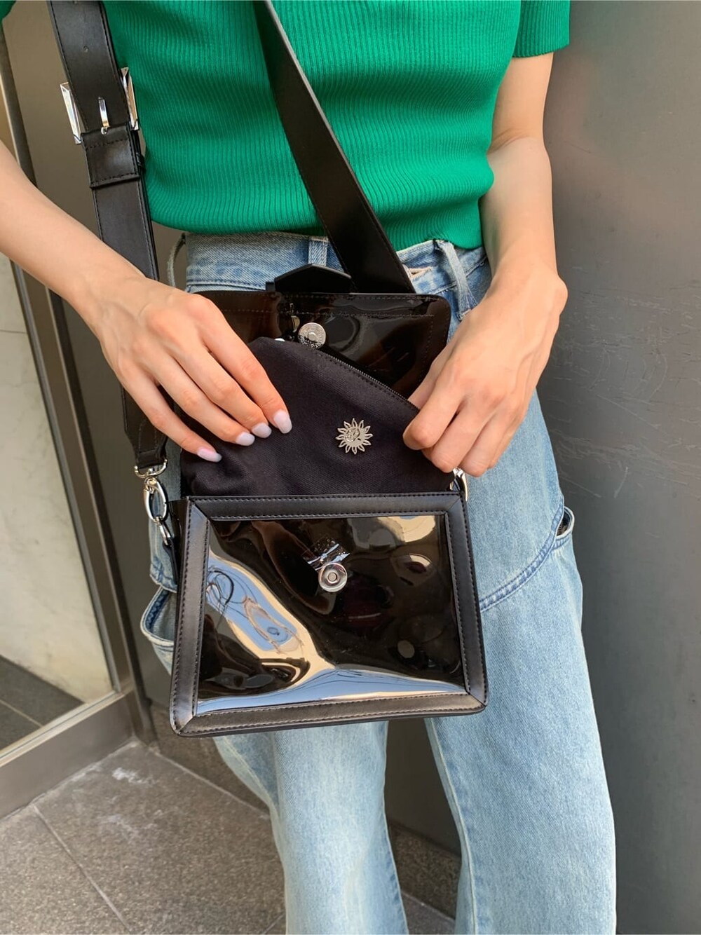 ブルー系のデニムパンツ、ブラック系のサンダル、ブラック系のショルダーバッグを着用したレディースの夏コーディネートの9枚目の写真