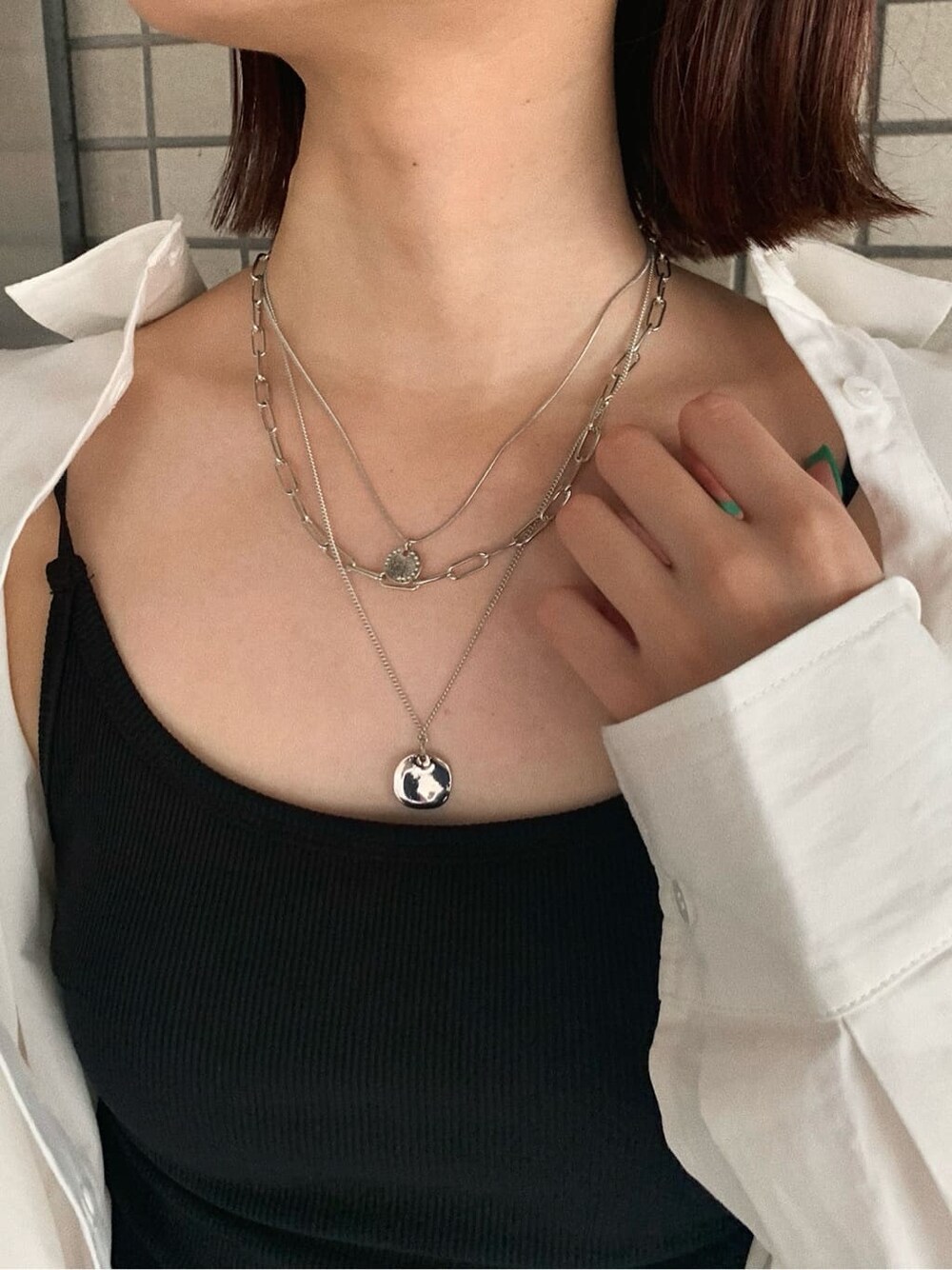 ブラック系のブーツ、ブラック系のスカート、ホワイト系のシャツ/ブラウスを着用したレディースの夏コーディネートの7枚目の写真