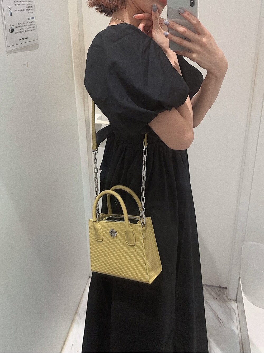 ブラック系のブーツ、イエロー系のショルダーバッグ、ブラック系のワンピースを着用したレディースの春コーディネートの8枚目の写真
