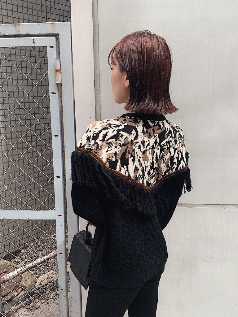 ブラック系のブーツ、ブラック系のハンドバッグ、ブラック系のニット/セーターを着用したレディースの秋コーディネートの3枚目の写真