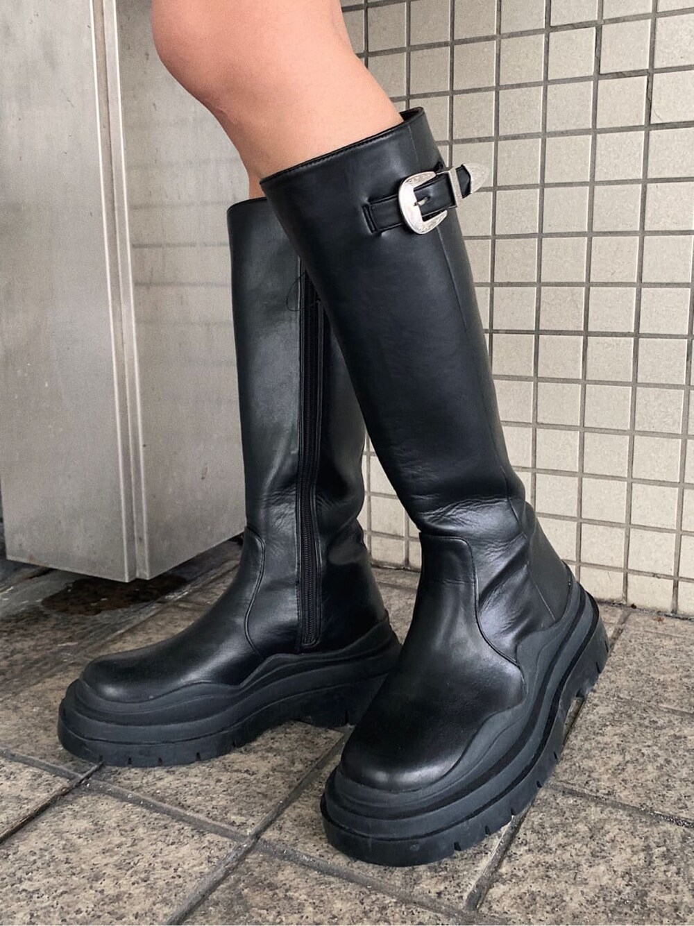 ブラック系のブーツ、ブラック系のデニムスカート、ブラック系のスウェットを着用したレディースの冬コーディネートの7枚目の写真