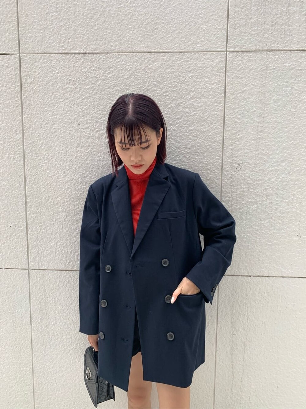 ブルー系のテーラードジャケット、ブラック系のハンドバッグ、ブラック系のブーツを着用したレディースの秋コーディネートの5枚目の写真