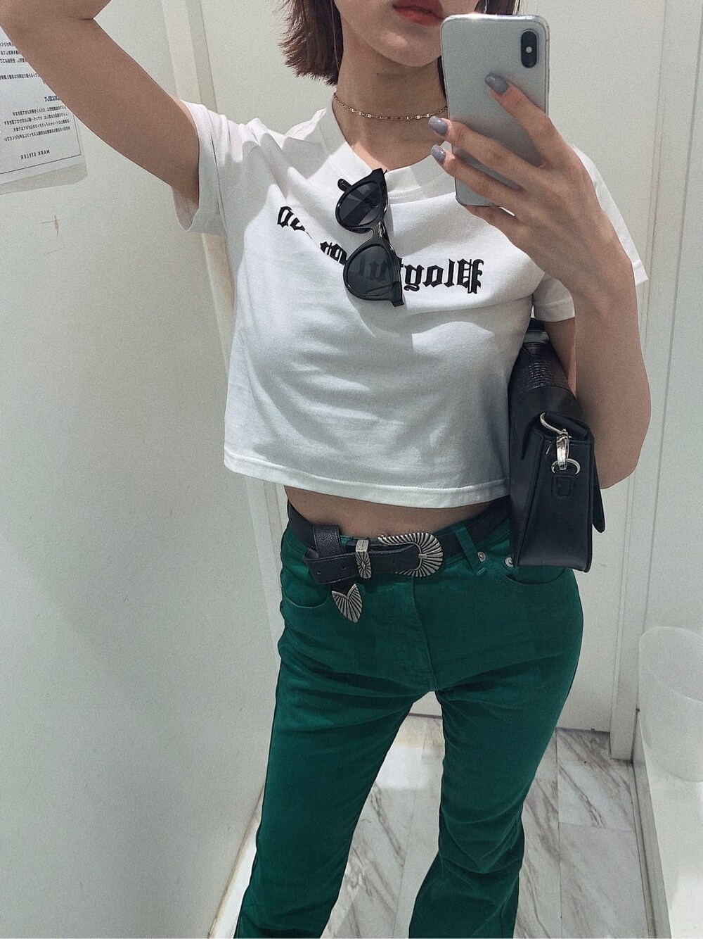 ブラック系のブーツ、ホワイト系のTシャツ/カットソー、ブラック系のショルダーバッグを着用したレディースの春コーディネートの2枚目の写真