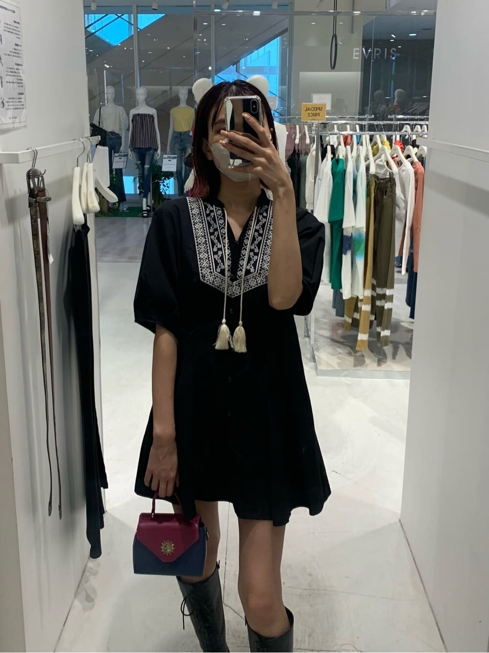 ブラック系のワンピース、ブラック系のブーツ、ブルー系のショルダーバッグを着用したレディースの夏コーディネートの3枚目の写真