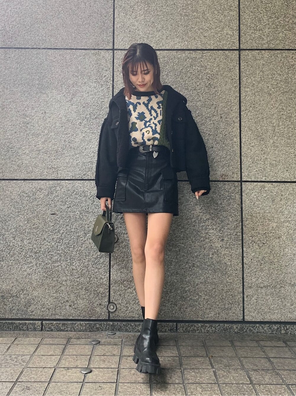 ブラック系のブーツ、ホワイト系のブルゾン、ブラック系のニット/セーターを着用したレディースの冬コーディネートの2枚目の写真