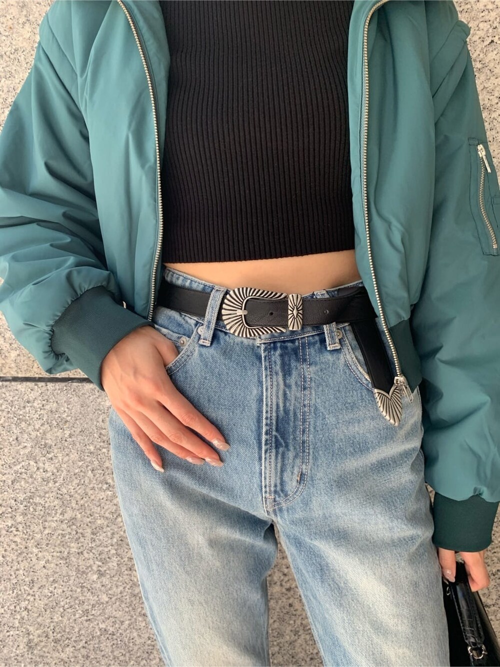 ブラック系のハンドバッグ、ブルー系のデニムパンツ、ブルー系のMA-1を着用したレディースの秋コーディネートの9枚目の写真