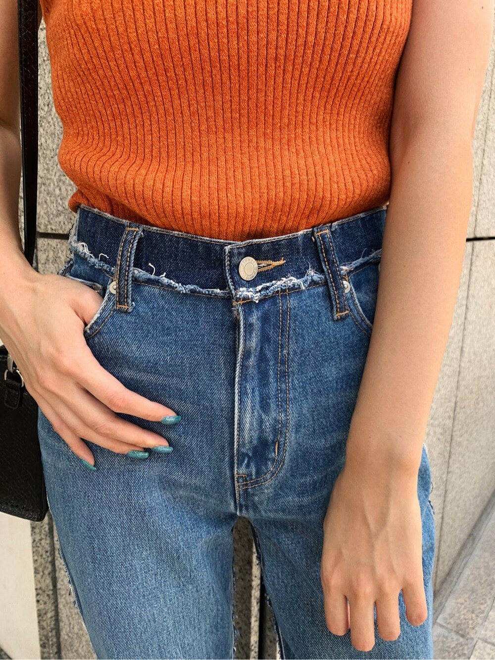 ブルー系のデニムパンツ、ブラック系のサンダル、オレンジ系のニット/セーターを着用したレディースの夏コーディネートの7枚目の写真