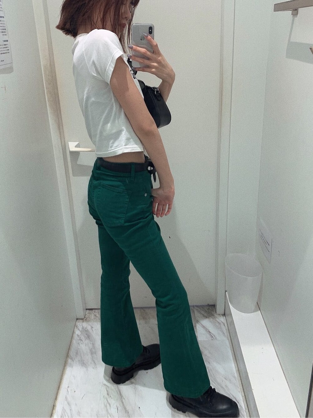 ブラック系のブーツ、ホワイト系のTシャツ/カットソー、ブラック系のショルダーバッグを着用したレディースの春コーディネートの3枚目の写真