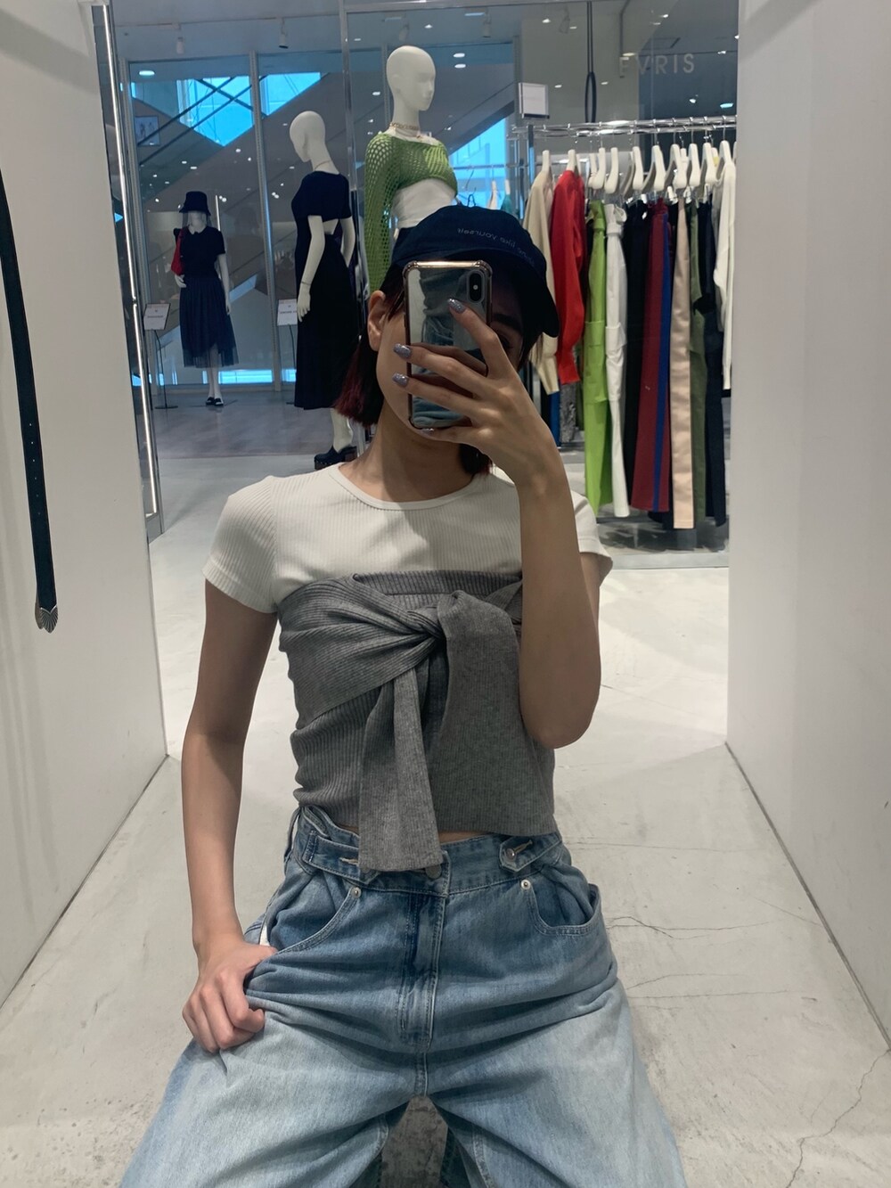 ブルー系のデニムパンツ、ブラック系のブーツ、グレー系のチューブトップを着用したレディースの春コーディネートの8枚目の写真