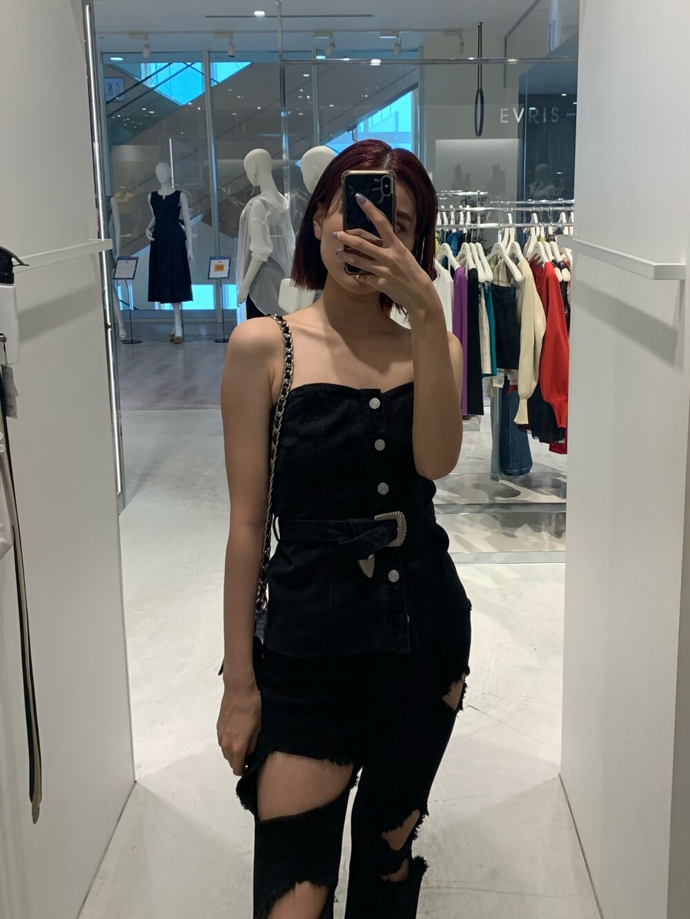 ブラック系のチューブトップ、ブラック系のデニムパンツ、ブラック系のショルダーバッグを着用したレディースの夏コーディネートの3枚目の写真