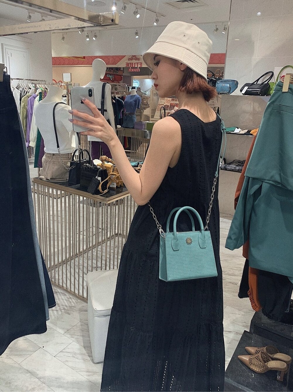 ブラック系のサンダル、ブラック系のワンピース、ブルー系のショルダーバッグを着用したレディースの春コーディネートの3枚目の写真