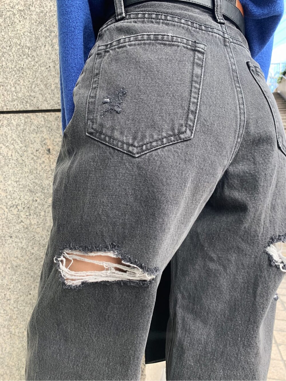 ブラック系のデニムパンツ、ブラック系のブーツ、ブラック系のショルダーバッグを着用したレディースの冬コーディネートの6枚目の写真