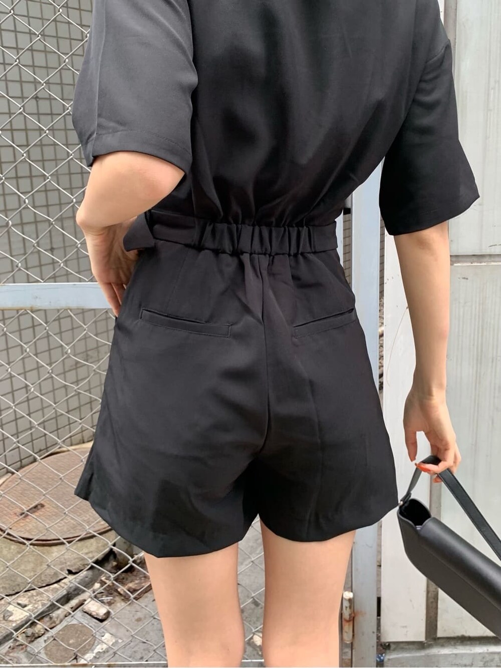 ブラック系のブーツ、ブラック系のつなぎ/オールインワン、ブラック系のショルダーバッグを着用したレディースの春コーディネートの7枚目の写真