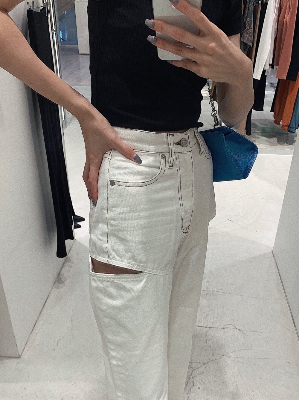 ブラック系のサンダル、ホワイト系のデニムパンツ、ブラック系のTシャツ/カットソーを着用したレディースの春コーディネートの4枚目の写真