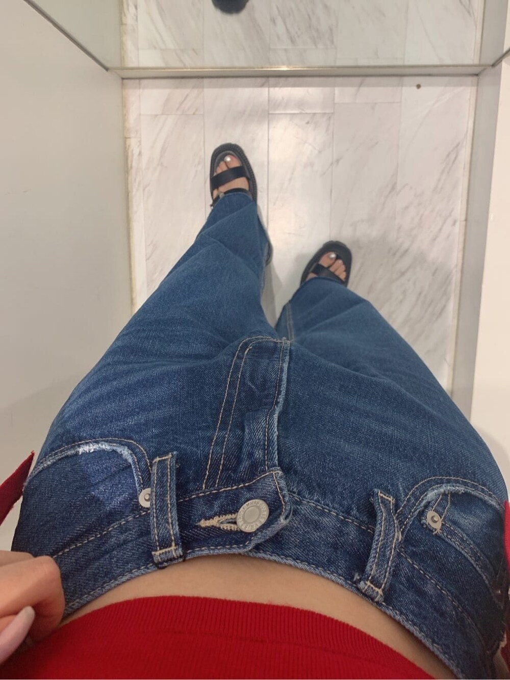 ブルー系のデニムパンツ、ホワイト系のショルダーバッグ、レッド系のニット/セーターを着用したレディースの夏コーディネートの5枚目の写真