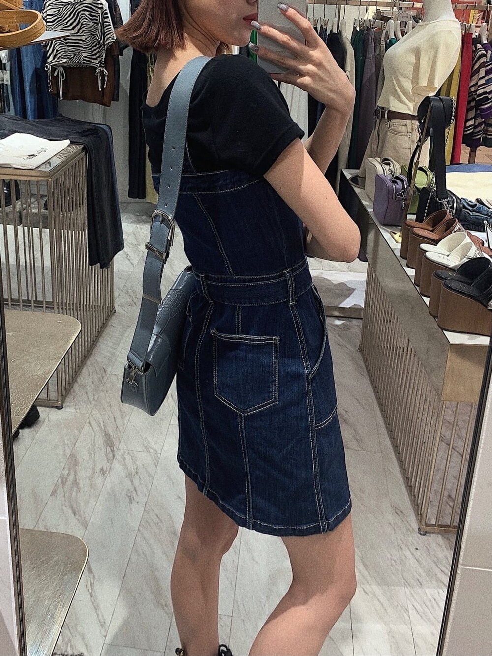 ブラック系のブーツ、ブラック系のTシャツ/カットソー、ブルー系のジャンパースカートを着用したレディースの春コーディネートの4枚目の写真