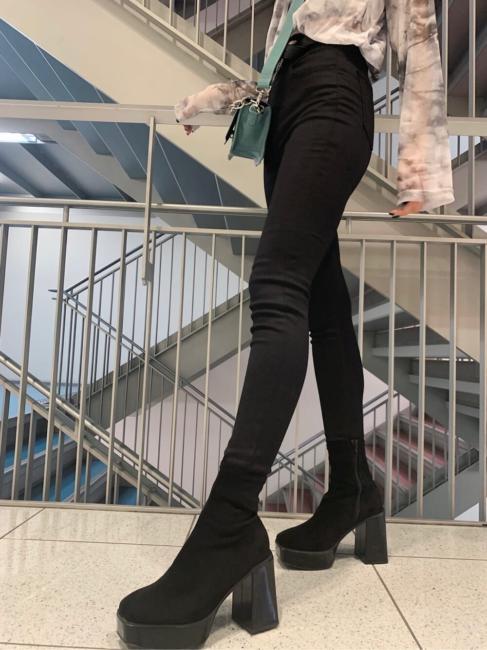 ブラック系のデニムパンツ、グレー系のTシャツ/カットソー、その他のブーツを着用したレディースの秋コーディネートの6枚目の写真