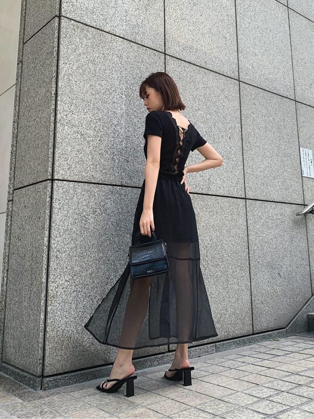 ブラック系のスカート、ブラック系のTシャツ/カットソー、ブラック系のサンダルを着用したレディースの夏コーディネートの2枚目の写真