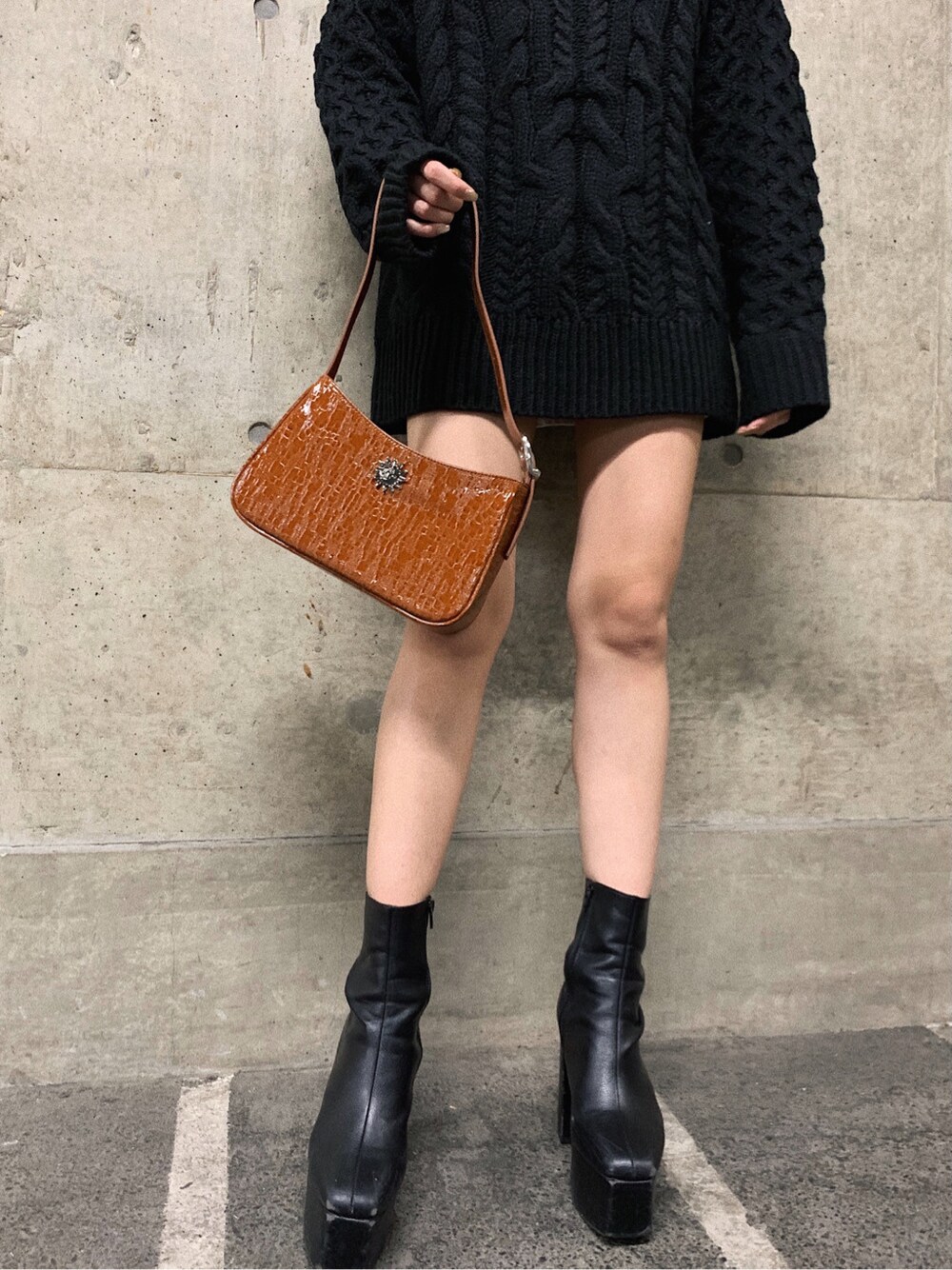 ブラウン系のショルダーバッグ、ブラック系のハットを着用したレディースの冬コーディネートの6枚目の写真