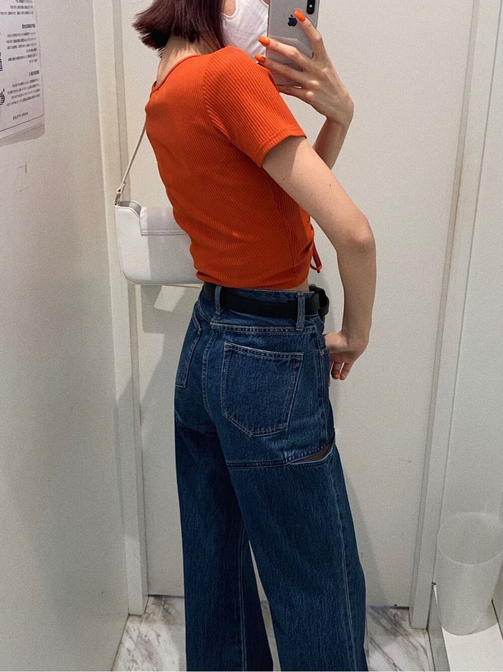 ブラック系のサンダル、ブルー系のデニムパンツ、ホワイト系のショルダーバッグを着用したレディースの春コーディネートの2枚目の写真