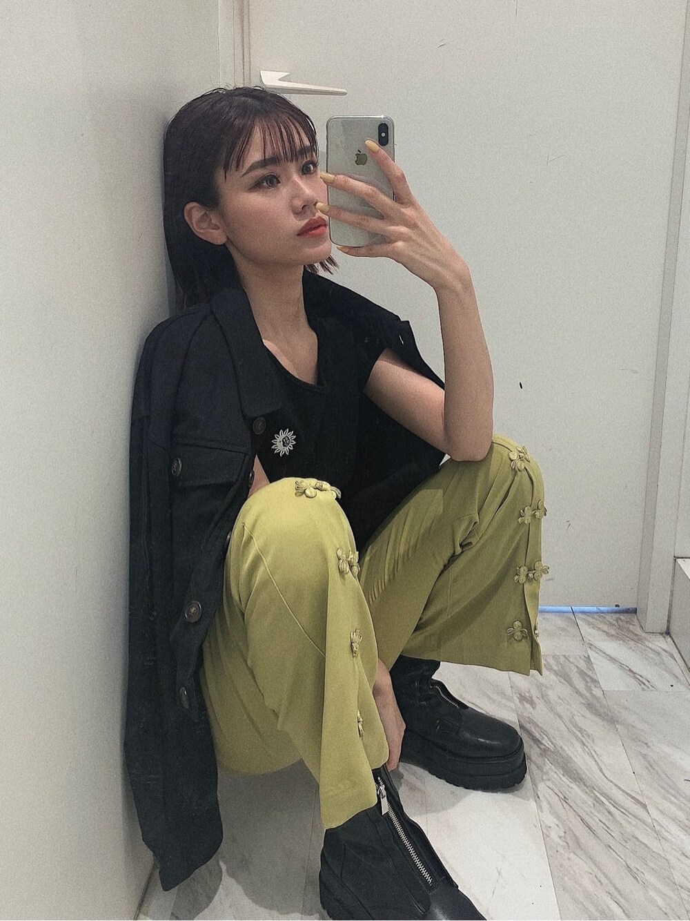 ブラック系のブーツ、ブラック系のブルゾン、グリーン系のその他パンツを着用したレディースの春コーディネートの5枚目の写真