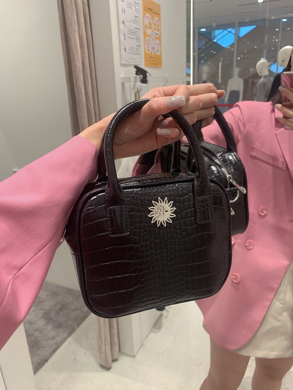 ピンク系のテーラードジャケット、ホワイト系のスカート、ブラック系のショルダーバッグを着用したレディースの冬コーディネートの8枚目の写真