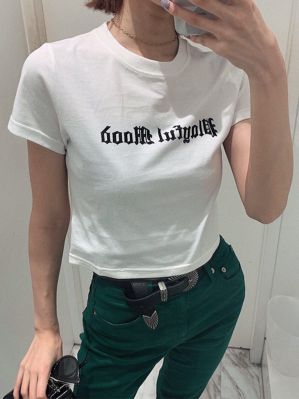 ブラック系のブーツ、ホワイト系のTシャツ/カットソー、ブラック系のショルダーバッグを着用したレディースの春コーディネートの4枚目の写真