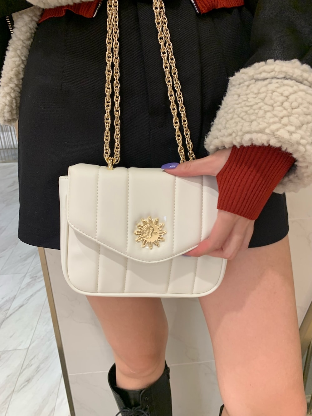 レッド系のニット/セーター、ブラック系のムートンコート、ブラック系のその他パンツを着用したレディースの夏コーディネートの6枚目の写真