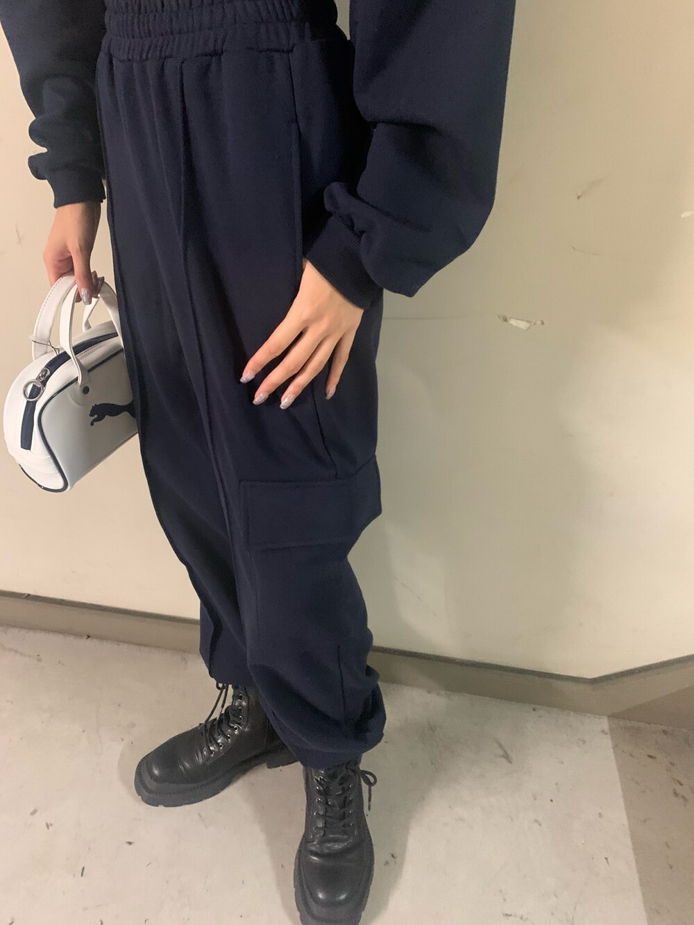 ブルー系のスウェット、ブルー系のスウェットパンツ、ホワイト系のハンドバッグを着用したレディースの秋コーディネートの6枚目の写真