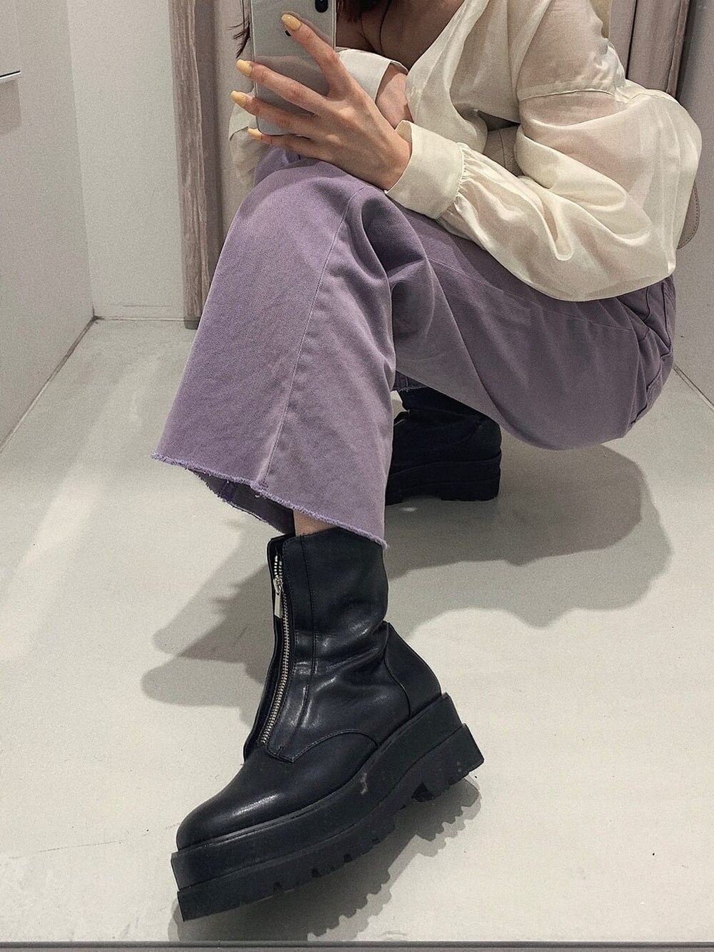 ブラック系のブーツ、ブラック系のキャミソール、パープル系のデニムパンツを着用したレディースの春コーディネートの8枚目の写真
