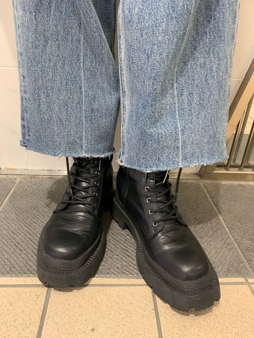 ブラック系のブーツ、ブルー系のデニムパンツ、ブルー系のショルダーバッグを着用したレディースの夏コーディネートの9枚目の写真