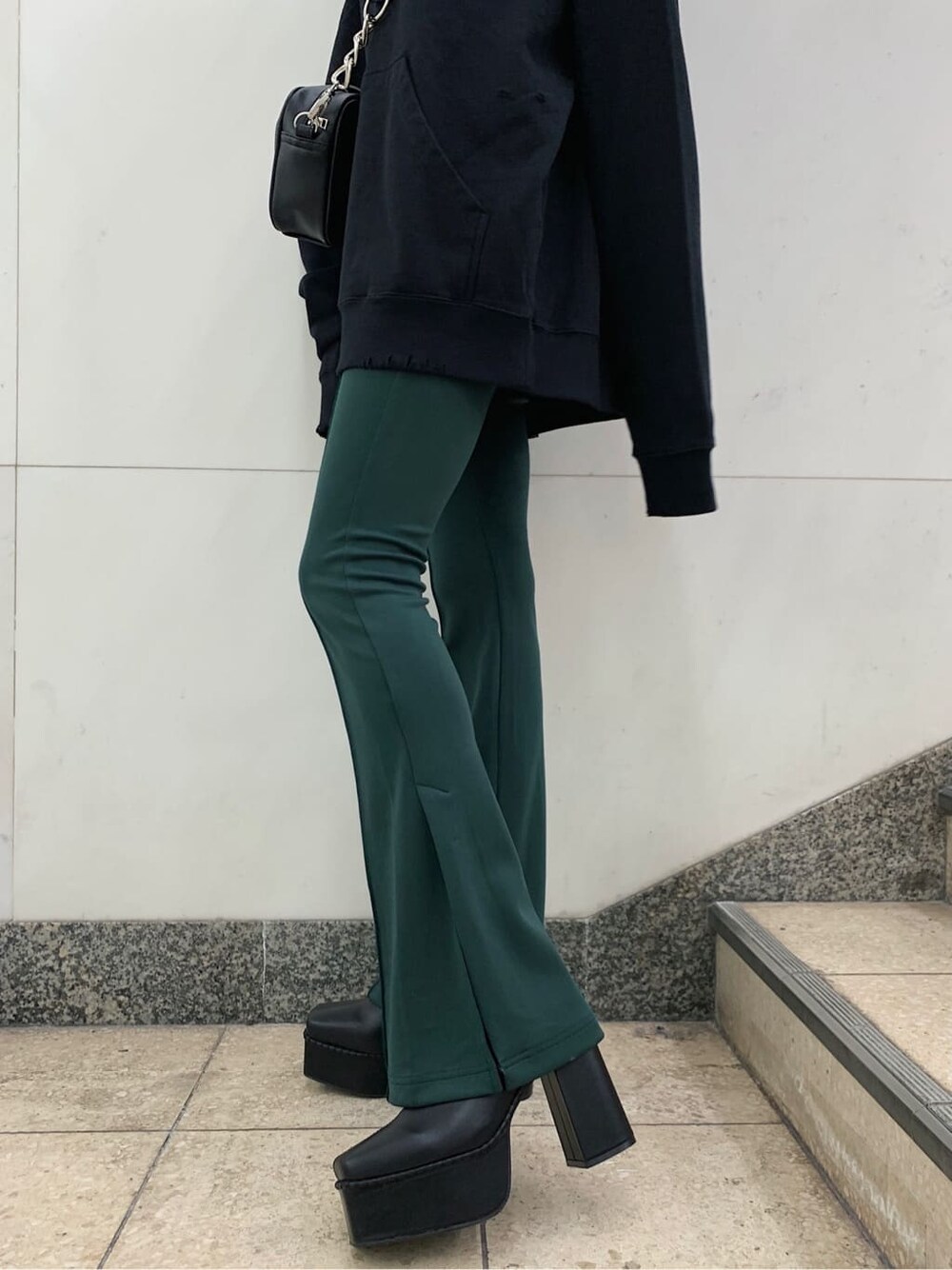 ブラック系のショルダーバッグ、ブラック系のブーツ、ブラック系のパーカーを着用したレディースの秋コーディネートの6枚目の写真