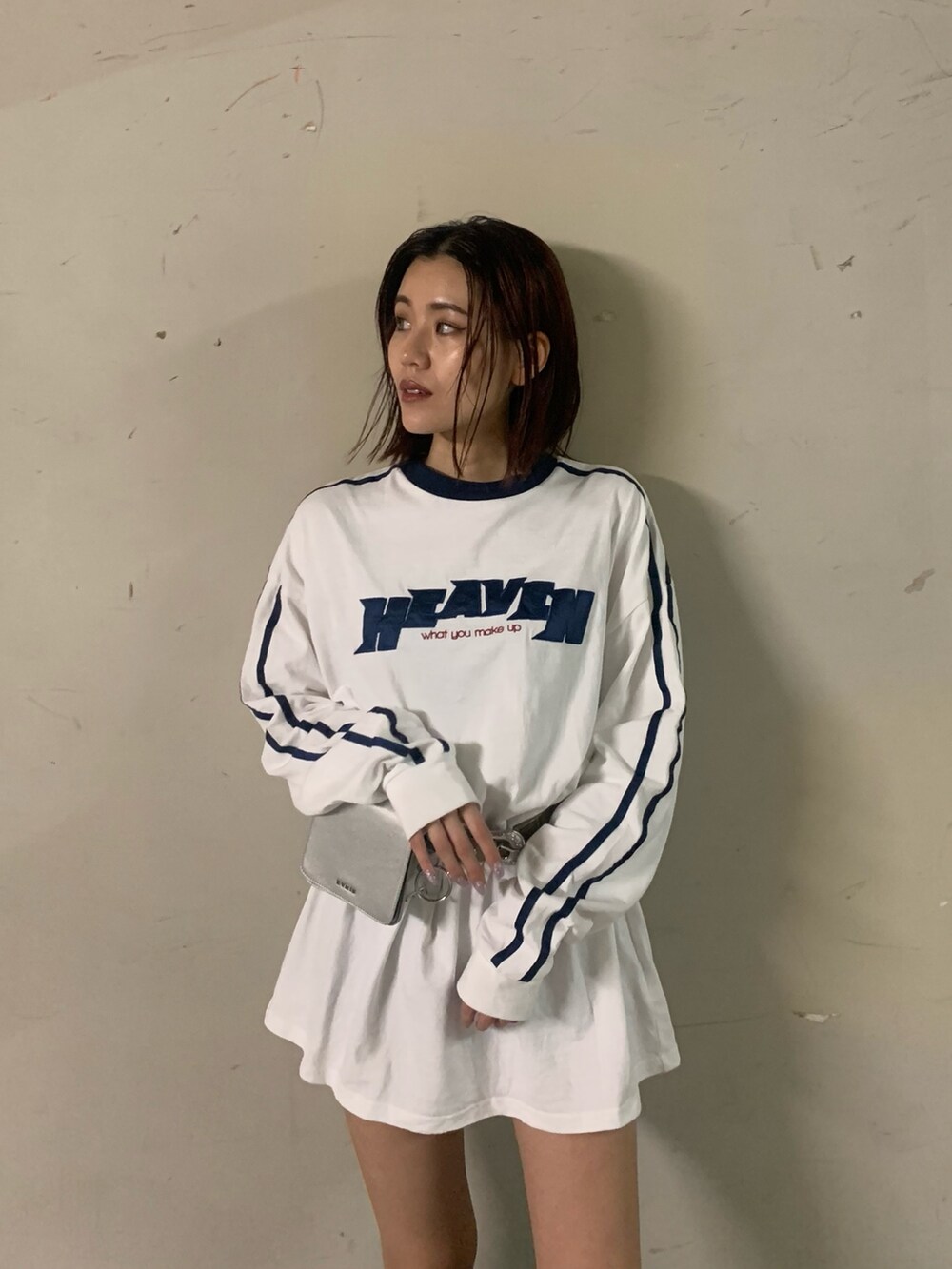 ホワイト系のワンピース、シルバー系のショルダーバッグ、ブラック系のブーツを着用したレディースの秋コーディネートの3枚目の写真