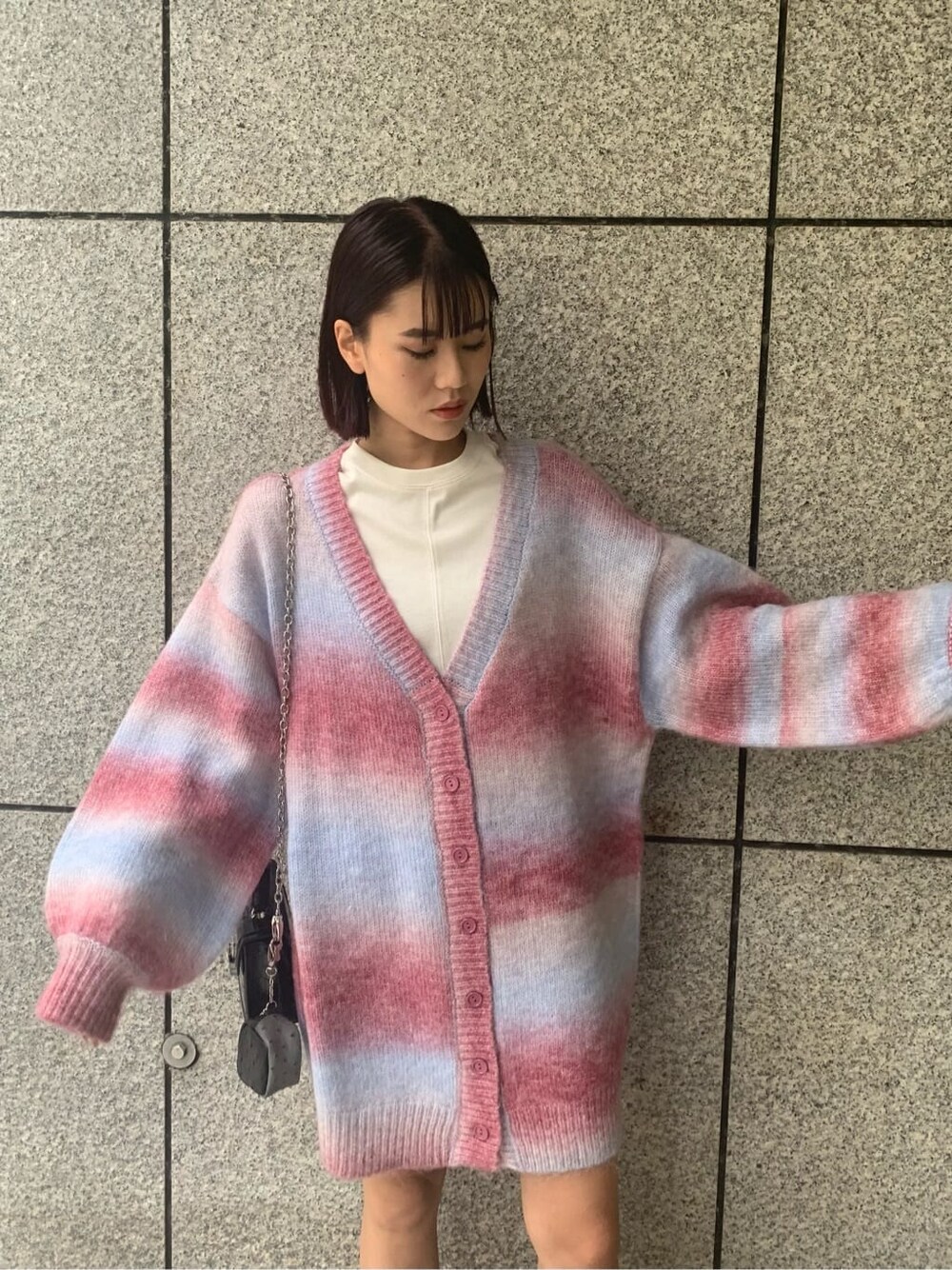 ブラック系のブーツ、ブラック系のハンドバッグ、ピンク系のカーディガン/ボレロを着用したレディースの秋コーディネートの6枚目の写真