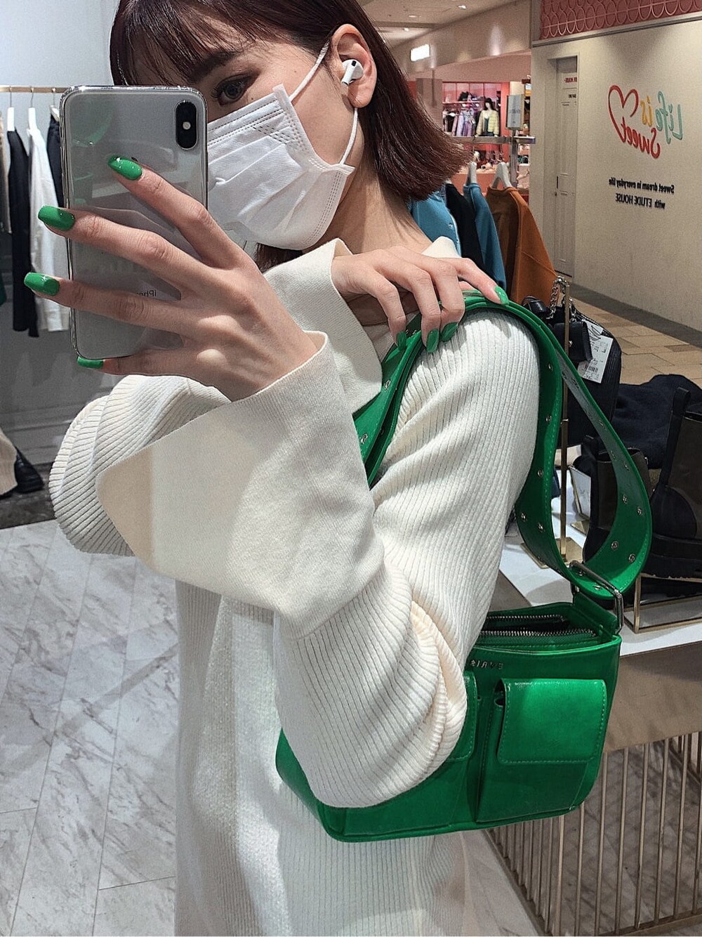 ホワイト系のワンピース、グリーン系のショルダーバッグ、ブラック系のブーツを着用したレディースの冬コーディネートの3枚目の写真