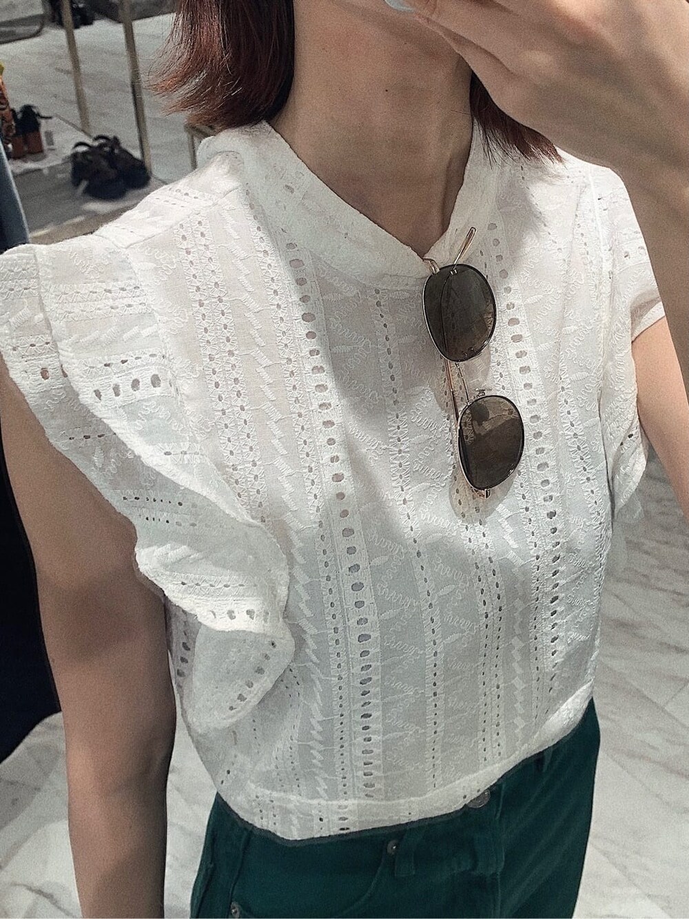 グリーン系のデニムパンツ、ホワイト系のタンクトップ、ホワイト系のサンダルを着用したレディースの春コーディネートの4枚目の写真