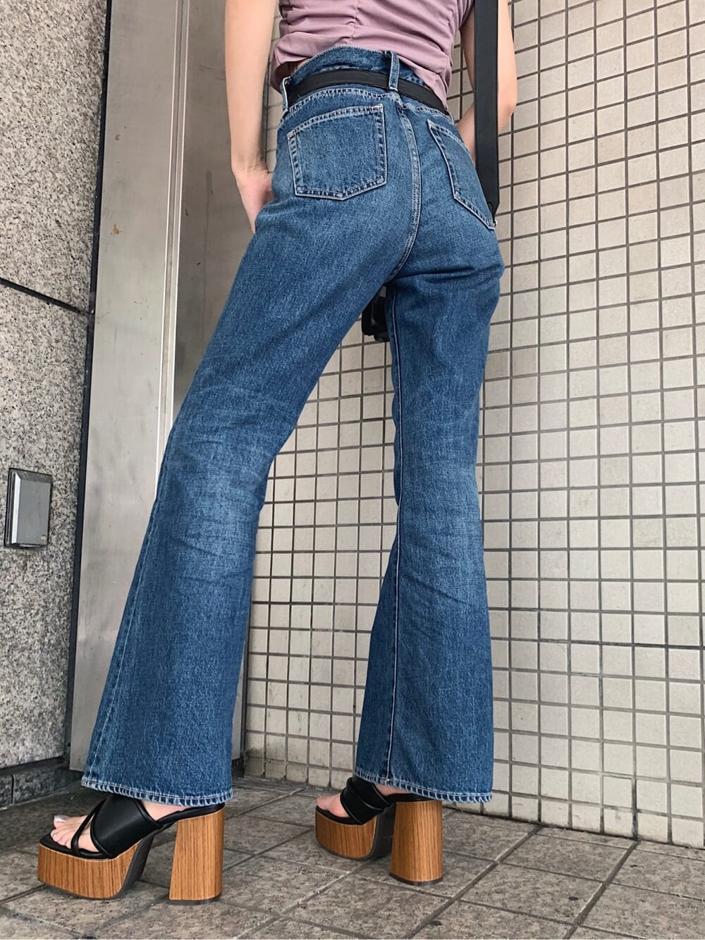 ブルー系のデニムパンツ、ブラック系のサンダル、ブラック系のベルトを着用したレディースの夏コーディネートの7枚目の写真