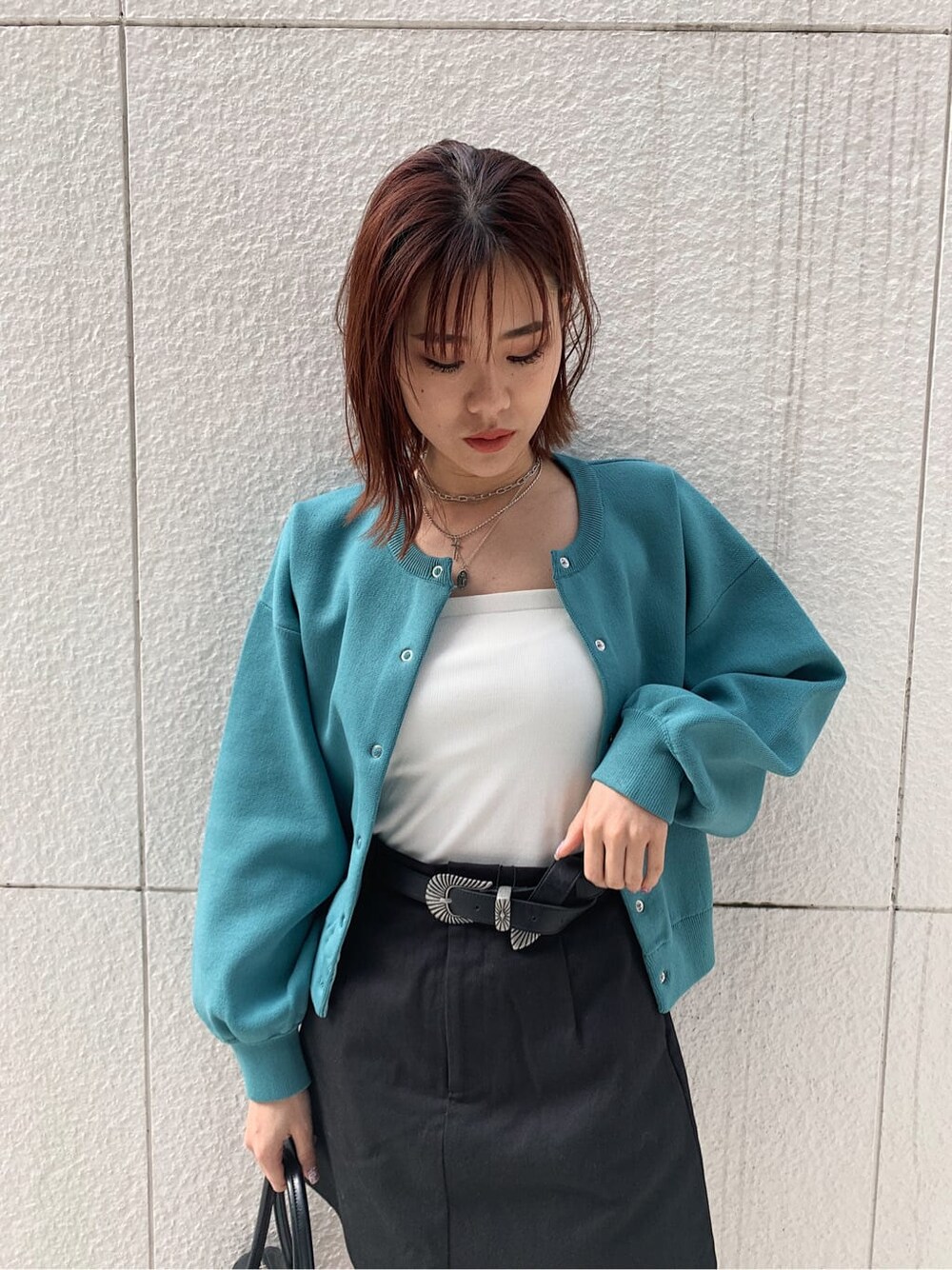 ブラック系のブーツ、ブラック系のスカート、ホワイト系のキャミソールを着用したレディースの冬コーディネートの4枚目の写真