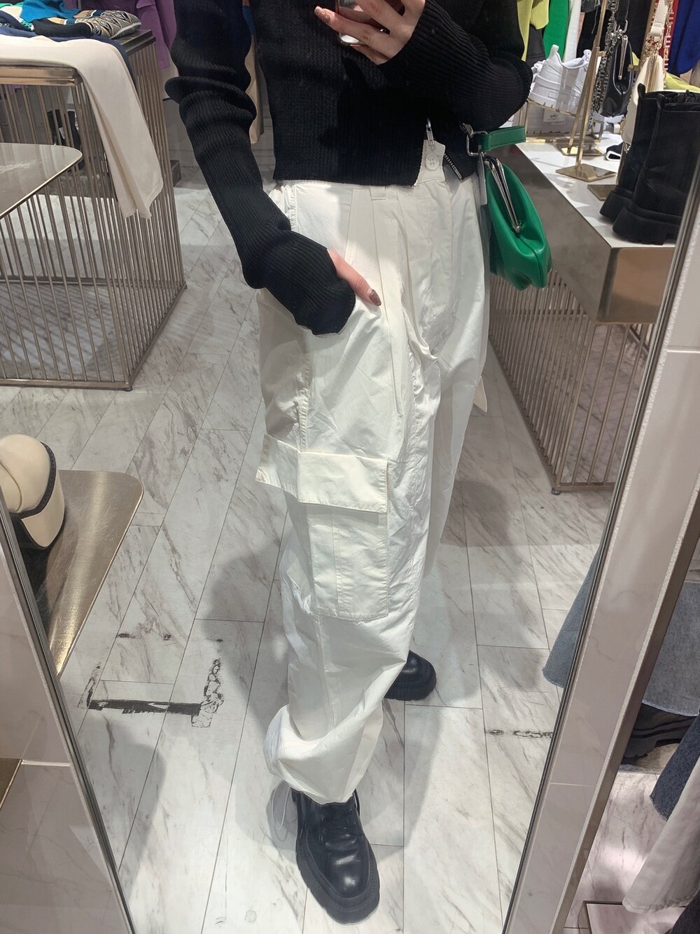 ホワイト系のカーゴパンツ、ブラック系のニット/セーター、グリーン系のショルダーバッグを着用したレディースの春コーディネートの7枚目の写真